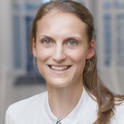 PD Dr. med. Anne Zaremba: Portr&auml;t einer l&auml;chelnden Frau in wei&szlig;er Kleidung vor einem unscharfen, hellen Hintergrund.